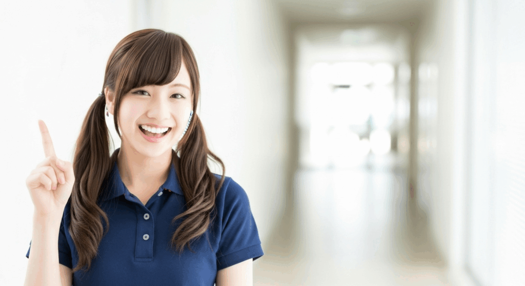 人差し指を上げて笑顔な介護職員の女性