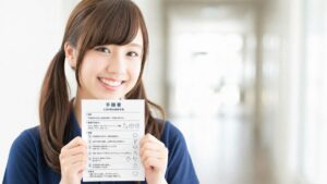 手順書を持ちながら笑顔を見せる若い女性介護職員